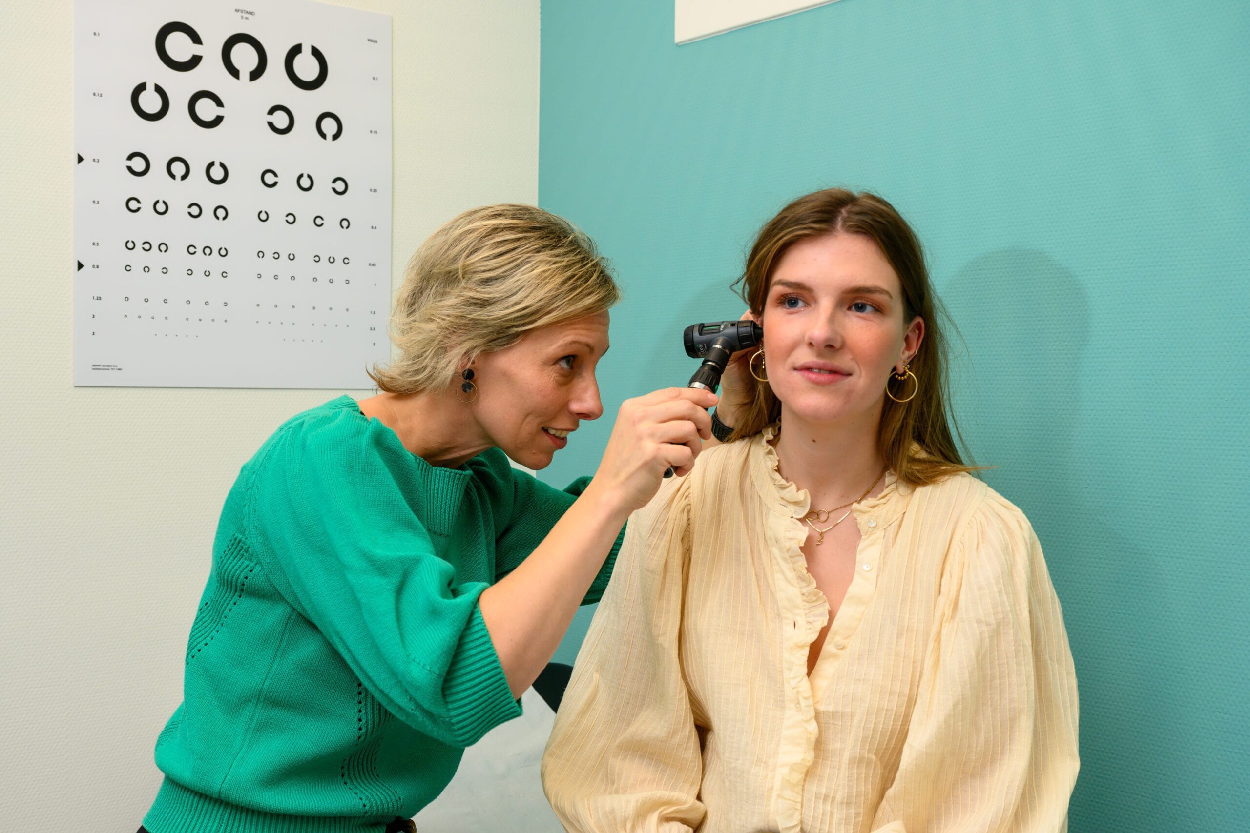 38. Huisarts Felicia kijkt in oor bij patient III